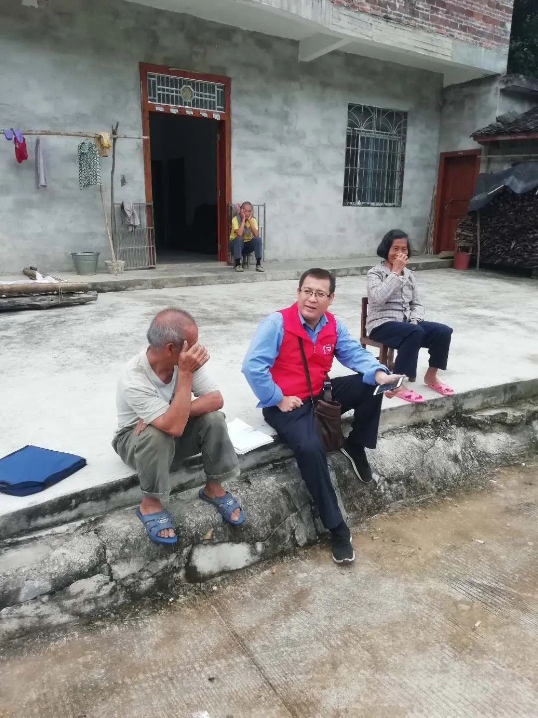 圖為許杰華（前排居中）到農(nóng)戶家中了解村情，商討產(chǎn)業(yè)發(fā)展思路